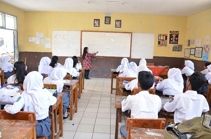 Guru sedang mengajar di kelas SMA